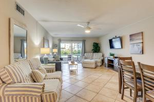 a living room with couches and a tv at Bayfront South Pasadena Condo with Resort Perks in St Pete Beach