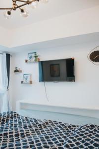 ein Schlafzimmer mit einem Bett und einem Fernseher an der Wand in der Unterkunft Stefan Staycation @ Azure North in San Fernando