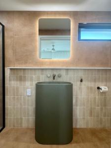 a bathroom with a green sink and a mirror at Pacific Sun Bargara in Bargara