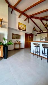 a large living room with wooden ceilings and a bar at JanHouse Ilhabela in Ilhabela
