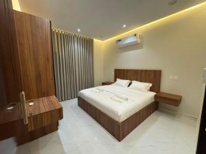 a bedroom with a large bed and a bathroom at الشقق الفاخرة luxury aparments in Medina
