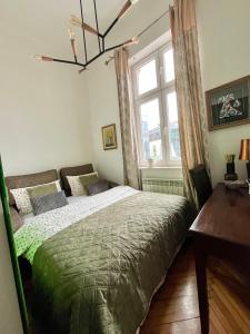 a bedroom with a green bed and a window at Historijski luksuz u Starom Gradu, Garage Parking in Sarajevo