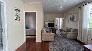 un soggiorno con un divano e un letto di Recanto pé na areia a Governador Celso Ramos