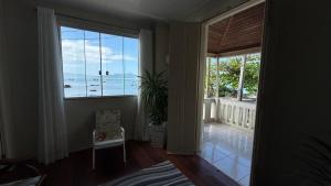 una camera con una grande finestra con vista sull'oceano di Recanto pé na areia a Governador Celso Ramos Altre 24 foto