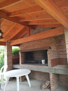 a patio with a brick fireplace with a wooden roof at Divina providencia in Merlo