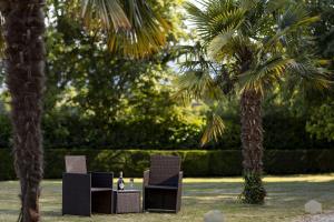 two chairs and a table under two palm trees at lakeside Estate in Bristol