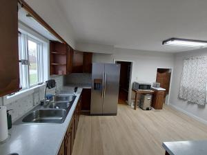 Home in Pulaski في Pulaski: مطبخ مع ثلاجة ستانلس ستيل وأرضيات خشبية