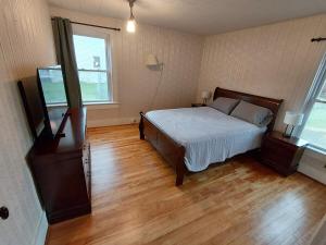 Home in Pulaski في Pulaski: غرفة نوم مع سرير وأرضية خشبية
