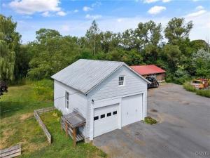 Home in Pulaski في Pulaski: مرآب أبيض بباب كبير في موقف السيارات