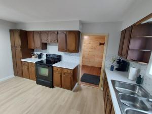 Home in Pulaski في Pulaski: مطبخ مع خزائن خشبية وفرن موقد +9 صور