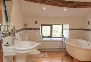 a bathroom with two sinks and a tub and a toilet at Grains Barn Farm in Burnley +25 photos
