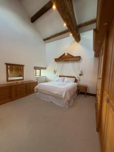 a bedroom with a large bed with a wooden headboard at Grains Barn Farm in Burnley