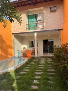 een huis met een zwembad ervoor bij Aconchego Paracuru in Paracuru