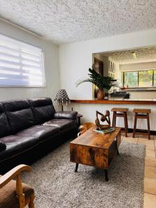 Una sala de estar con un sofá y una mesa de café. en Bonsai House, en Brasil