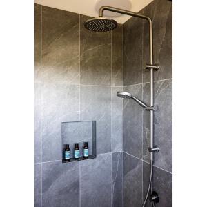 a bathroom with a shower with three bottles in it at Crater View Boutique Eco Apartment in Koroit