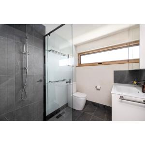 a bathroom with a shower and a toilet and a sink at Crater View Boutique Eco Apartment in Koroit +27 photos