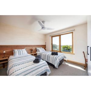 a bedroom with two beds and a window at Crater View Boutique Eco Apartment in Koroit