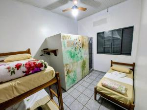 a bedroom with two beds and a painting on the wall at Hotel Pasettus in Bela Vista do Paraíso