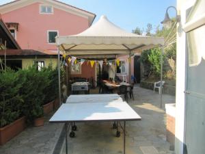a table under a white canopy in a courtyard at Agriturismo Cele in Celle Ligure