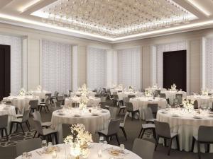 ein Bankettsaal mit weißen Tischen und Stühlen in der Unterkunft Sofitel Riyadh Hotel & Convention Centre in Riad