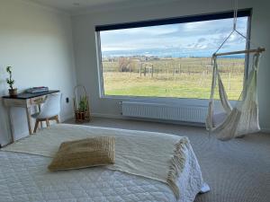 LeñaduraHermosa Casa con vista al Estrecho de Magallanes的一间卧室，里面有一张床和一扇大窗户。