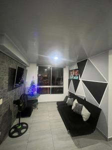 a living room with a black couch and a christmas tree at Apartamento Vacacional con Piscina in Ibagué