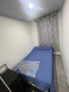 a small bedroom with a blue bed and a window at Apartamento Vacacional con Piscina in Ibagué +16 photos