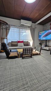 un soggiorno con un divano e una TV di YAHouse a Chiba