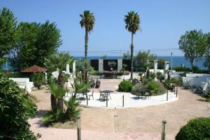 a courtyard with tables and chairs and palm trees at Residence Camping Atlantide in Monopoli