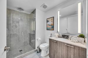 a bathroom with a shower and a toilet and a sink at Modern Studio City Views in Miami +19 photos