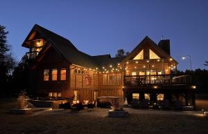 una grande casa in legno con luci sopra la notte di Lake Tower Lodge a New Rome