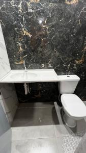 ein Badezimmer mit einer weißen Toilette und einem Waschbecken in der Unterkunft Studio no Centro da Cidade in Parauapebas + 6 Fotos