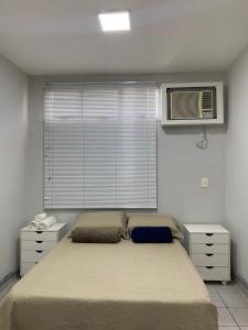 普雷图河畔圣若泽Suítes nas proximidades HB, HCM e Famerp的一间卧室配有一张床,窗户配有空调
