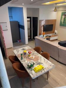 ein Wohnzimmer mit Tisch und Couch in der Unterkunft Two Sisters Villa in Accra