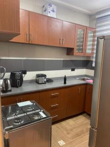 eine Küche mit einem Herd und Holzschränken in der Unterkunft Two Sisters Villa in Accra