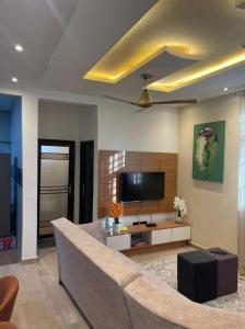 ein Wohnzimmer mit Couch und Flachbildfernseher in der Unterkunft Two Sisters Villa in Accra + 8 Fotos