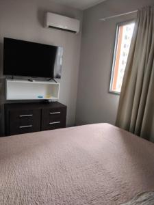 una camera da letto con un letto e una TV a schermo piatto di Amy House a Vila Velha