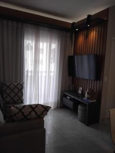 un soggiorno con TV a schermo piatto di fronte a una finestra di Amy House a Vila Velha