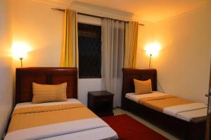 2 letti in una camera con 2 lampade accese di Green Valley Palace a Buzzi