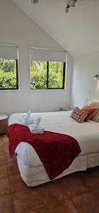 Waiheke IslandSerene One Bedroom Seaview Chalet的一间带大床和两扇窗户的卧室