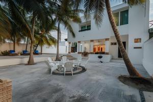 a patio with a table and chairs and palm trees at Espectacular casa en Progreso con alberca in Progreso