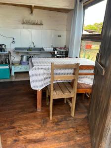 a table and a chair in a small kitchen at Cabaña Cica in Punta Del Diablo