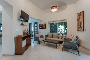 a living room with a couch and a tv at Espectacular casa en Progreso con alberca in Progreso