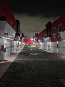 an empty parking lot at night with red buildings at Motel Éxtasis in Mexico City