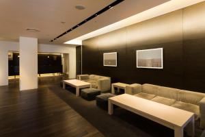 a waiting room with couches and tables in a building at Hotel Sunroute Tokushima in Tokushima