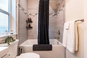 a bathroom with a toilet and a bath tub at New modern home - movie and game room - Family Friendly in Post Falls