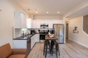 a kitchen with white cabinets and a table with stools at New modern home - movie and game room - Family Friendly in Post Falls +20 photos