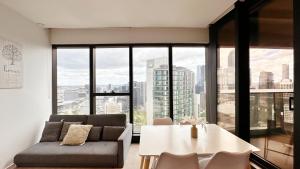 メルボルンにあるPrima Tower Apartment Face to Crown by GoodLiveのソファとテーブルのあるリビングルーム