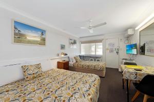 a hotel room with a bed and a desk at Bundaberg Coral Villa Motor Inn in Bundaberg +37 photos