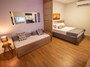 a bedroom with two beds and a couch in it at ibis Styles Bonito in Bonito